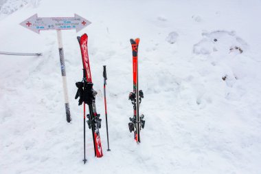 Karlı dağ ortamında bir çift kırmızı kayak ve sırık. 15 Aralık 2024 'te Romanya.