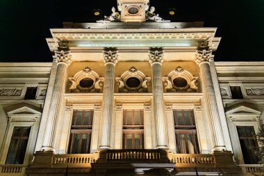 Aydınlatılmış kolonları olan tarihi binanın görkemli gece manzarası. 8 Mart 2025 Bükreş Romanya.