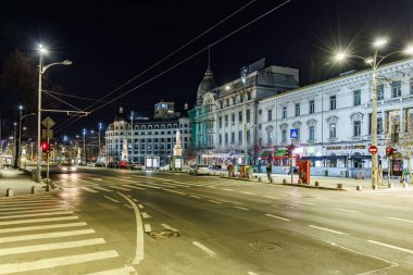 Tarihi mimarisi ve ışıl ışıl ışıklandırmasıyla dolu şehir gece sahnesi. 8 Mart 2025 Bükreş Romanya.