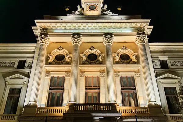 Aydınlatılmış kolonları olan tarihi binanın görkemli gece manzarası. 8 Mart 2025 Bükreş Romanya.
