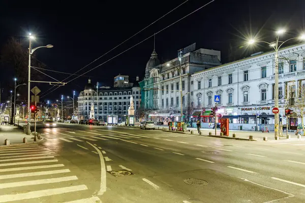 Tarihi mimarisi ve ışıl ışıl ışıklandırmasıyla dolu şehir gece sahnesi. 8 Mart 2025 Bükreş Romanya.
