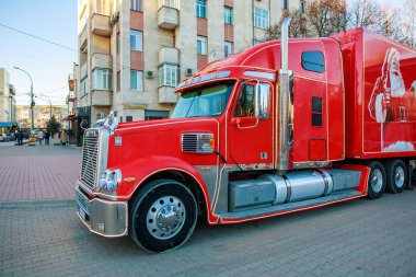 Yanında Coca Cola reklamı olan kırmızı bir kamyonet. Kamyon tuğla bir yolda park halinde. 27 Aralık 2023 Balti Moldova