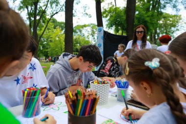 Çocuklar çeşitli çocuklar ve eğitmenlerle açık havada sanat faaliyetinde bulunuyorlar. 31 Mayıs 2024 Balti Moldova.
