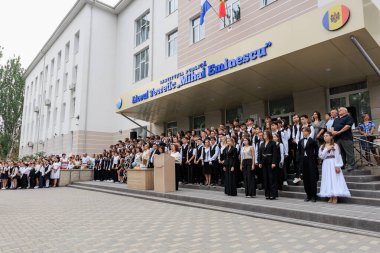 Çeşitli kalabalık ve mezunlarla Avrupa binasının dışında lise mezuniyet töreni. 2 Eylül 2024 Balti Moldova.