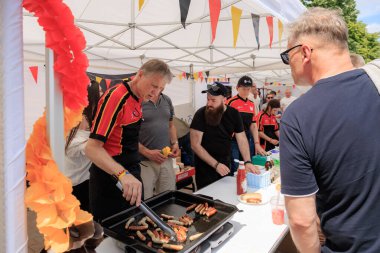 Alman gönüllüler 19 Mayıs 2024 'te Balti Moldova' da Avrupa Günü 'nde ızgara sosis pişiriyor ve otantik Alman mutfağını ziyaretçilerle paylaşıyor.
