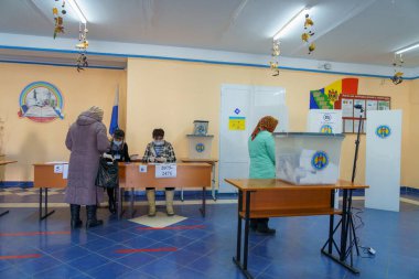 Seçim sandıkları ve oy sandıklarıyla oy kullanan insanlar. 21 Kasım 2021 Balti, Moldova.