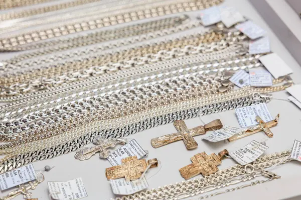 Altın ve gümüş zincirler ve masada sergilenen haç kolyeler. 3 Kasım 2023 Balti Moldova.