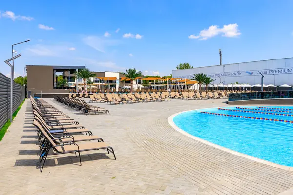 İçinde bir sürü sandalye ve şemsiye olan bir havuz. Sandalyeler havuzun etrafına dizildi ve şemsiyeler gölge sağlamak için kuruldu. Manzara rahatlatıcı ve davetkar. 8 Haziran 2024 Balti Moldova