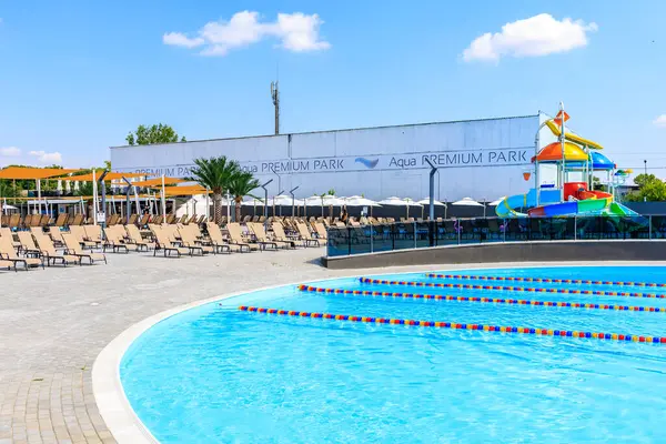 Arka planda beyaz bir bina olan bir havuz. Havuz sandalyeler ve şemsiyelerle çevrilidir. 8 Haziran 2024 Balti Moldova