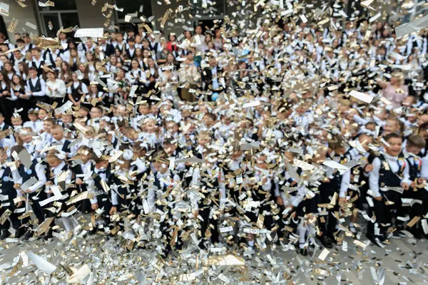 Okul kutlamalarında büyük bir grup üniformalı çocuğun üzerine konfeti yağmuru. 2 Eylül 2024 Balti Moldova.