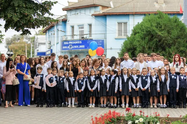 Bir grup beyaz okul çocuğu ve yetişkin açık hava töreninde. 2 Eylül 2024 Balti Moldova.