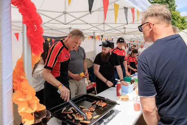 Alman gönüllüler 19 Mayıs 2024 'te Balti Moldova' da Avrupa Günü 'nde ızgara sosis pişiriyor ve otantik Alman mutfağını ziyaretçilerle paylaşıyor.