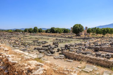 Bir sürü taş kalıntısı olan geniş bir açık alan. Harabeler tarlaya saçılmış ve gökyüzü açık ve mavi. Yunanistan 'ın antik Filippi kentinin kalıntıları