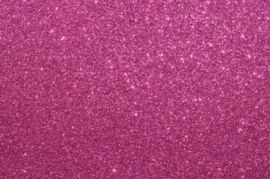 Pembe bir arka plan ve parlak bir doku. Arka plan pembe ve simler de pembe. Parıltı arka fonun her tarafına dağılmış, parlak ve parıltılı bir görünüm veriyor.