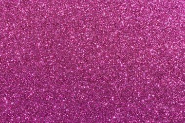 Parlak parçacıkların olduğu pembe bir arkaplan. Parıltı tüm arka plana saçılmış.