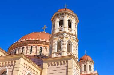 Arka planda mavi gökyüzü olan büyük bir kilise. Bina kırmızı ve beyaz fayanslarla kaplı.