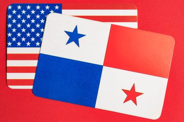 Kırmızı arkaplanda ABD ve Panama bayrakları çift gösterimi.