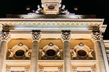 Romanya - Romanya Ulusal Bankası 'nın gece vakti aydınlatılmış neoklasik yazıt cephesi.