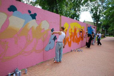 Genç sanatçılar açık havada renkli grafiti resimleri yapıyorlar. 31 Mayıs 2024 Balti Moldova.
