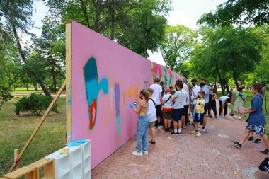 Çeşitli grup resimleriyle parktaki toplum sanatı projesi. 31 Mayıs 2024 Balti Moldova.