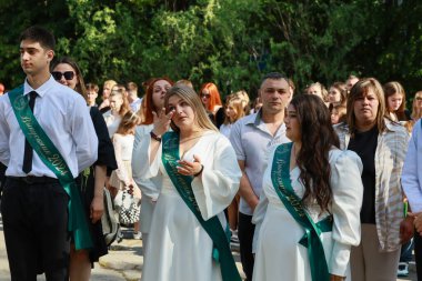 Beyazlar içinde genç beyaz mezunlarla mezuniyet töreni. 31 Mayıs 2024 Balti Moldova.