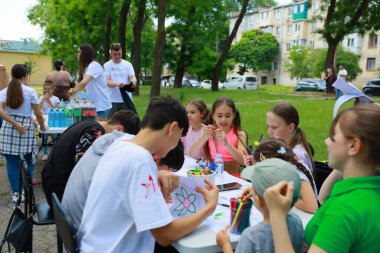 Bir grup beyaz çocuk parkta el sanatları ve el sanatları faaliyetlerinden keyif alıyor. 31 Mayıs 2024 Balti Moldova.