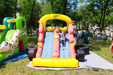 Çocuk, açık hava aile eğlence gününde şişme kaydırağın keyfini çıkarıyor. 31 Mayıs 2024 Balti Moldova.