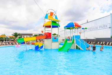 Renkli bir kaydırak ve gökkuşağı kaydırağıyla büyük bir su parkı. İnsanlar suda oynuyorlar. 8 Haziran 2024 Balti Moldova