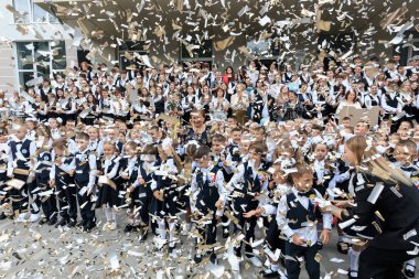 Konfeti ortasında hevesli çocuklar ve yetişkinlerin olduğu bir kutlama okulu etkinliği. 2 Eylül 2024 Balti Moldova.