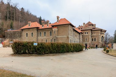 Önünde mavi bir işaret olan büyük bina, Cantacuzino Kalesi. 15 Aralık 2024 Busteni Romanya.