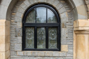 Siyah çerçeveli ve vitray pencereli bir pencere. 15 Aralık 2024 Busteni Romanya.