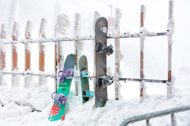 Kış mevsiminde kar kaplı snowboardlar çitin üzerinde dinleniyor. 15 Aralık 2024 'te Romanya.