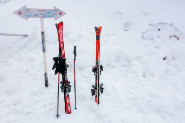 Karlı dağ ortamında parlak kırmızı kayaklar ve sırıklar. 15 Aralık 2024 'te Romanya.