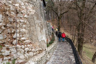 Bir grup insan, Drakula Kalesi 'nde, taştan bir yolda yürüyor. 16 Aralık 2024 Bran Romanya.