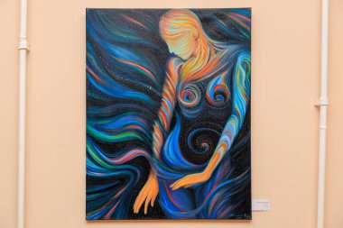 Mavi arka planı olan bir tabloda bir kadın tasvir ediliyor. Kadın mavi bir elbise giyiyor ve mavi bir saç bandı var. 12 Mart 2024 Balti Moldova