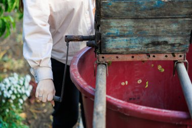 Bir kadın çiftlik şarabı üretiminde eziciyle çalışıyor. Seçici odaklı arkaplan ve metin için alanı kopyala