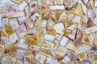 Taş ve beyaz fayanslardan yapılmış bir duvar. Duvar çok desenli ve çok detaya sahip.