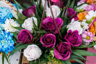 Pembe ve beyaz güllerin karışımı bir buket çiçek. Düzenleme farklı renk ve dokuların karışımıyla renkli ve canlı. Çiçekler bir sepete konur.