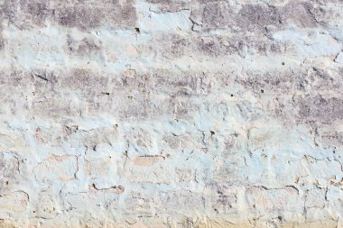 Mavi beyaz tuğlalı bir duvar. Duvar eski ve pürüzlü bir dokusu var. Mavi ve beyaz renkler duvara eşsiz ve ilginç bir görünüm kazandırıyor.