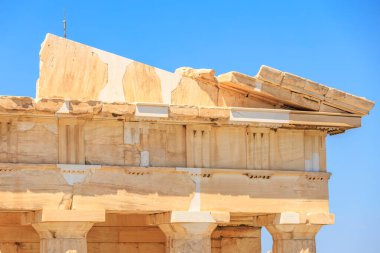 Binanın bir sürü beyaz ve kahverengi taşı var. Taş yontulmuş ve kırılmış. Bina Atina 'daki Akropolis' te bir tarafa eğiliyor.