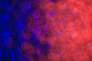 Kırmızı ve mavi dairelerin bulanık bir görüntüsü. Renkler canlı ve daireler üst üste biniyor, hareket ve enerji hissi yaratıyor.