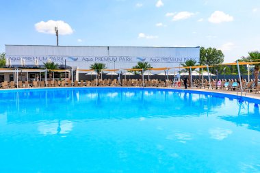 Arkasında beyaz bir bina olan büyük bir havuz. Havuz şezlonglar ve şemsiyelerle çevrilidir. 8 Haziran 2024 Balti Moldova
