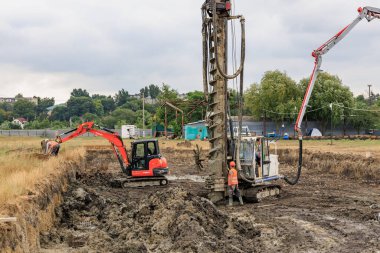 Bulutlu bir günde sondaj kulesi ve kazıcılı inşaat alanı. 25 Haziran 2024 Balti Moldova