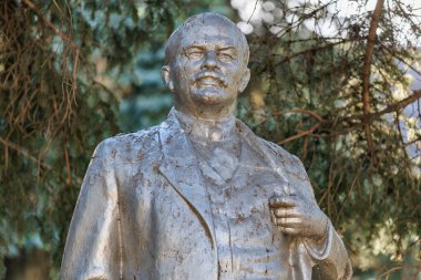 Arkaplanda ağaçlar olan erkek figürünün bronz heykeli, Lenin. 13 Ekim 2024 Basarabeasca Moldova.