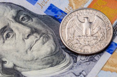 Amerika Birleşik Devletleri 'nin çeyrek dolarlık parası 100 dolarlık banknotun üstünde. Bozuk para gümüş ve üzerinde bir kartal var.