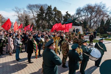Bayraklar ve kalabalıkla açık hava gösterisinde bando eşliğinde askeri geçit töreni. 26 Mart 2024 Balti, Moldova.