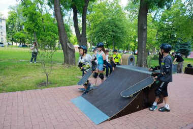 Genç kaykaycılar şehir parkındaki kaykay rampasında pratik yapıyor. 31 Mayıs 2024 Balti Moldova.