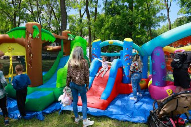 Çocuklar parkta renkli şişme oyun alanının tadını çıkarıyorlar. 31 Mayıs 2024 Balti Moldova.