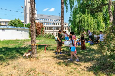 Parkta balonla oynayan bir grup çocuk. Sahne neşeli ve neşelidir. 1 Haziran 2024 Balti Moldova.