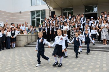 Okul seremonisinde el ele tutuşan bir grup genç çocuk. 2 Eylül 2024 Balti Moldova.